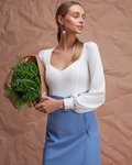 Блуза трикотажная белого цвета с фигурным вырезом и пышным рукавом